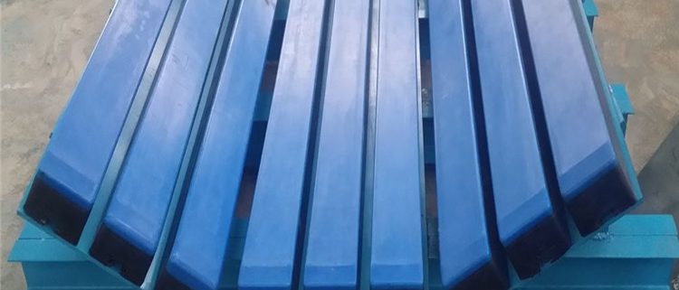 Conveyor load-zone impact bed with longitudinal bars and inclined side supports