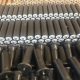 Polymer conveyor roller assemblies with metal shaft ends
