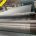 Parallel steel reinforcement cords positioned along a conveyor belt production line