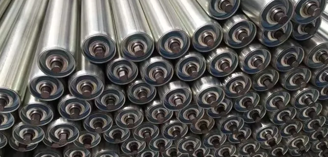 Steel conveyor rollers stacked with bearing ends and shaft interfaces visible