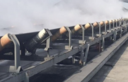 Bulk material conveyor belt supported by troughing rollers along the carrying run